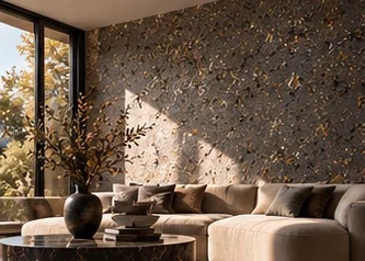 Salon baigné de soleil, mur FERRÉLYS ÉCLATS graphite semé d'éclats or, canapé écru et table en marbre sombre