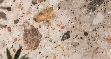 Éclats de pierre beige, brun et gris sur fond ivoire, vus de près