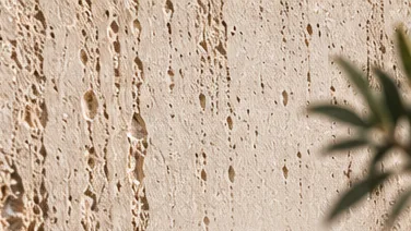 Détail TRAVERTINA ivoire : strates verticales ponctuées de cavités